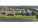 Aerial view of homes backing onto a serene lake, with screened-in pools and meticulously manicured lawns at 11414 Juglans Dr, Odessa, FL 33556