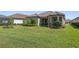 Expansive backyard with lush green grass, manicured landscaping, and covered patio area, perfect for outdoor relaxation at 11414 Juglans Dr, Odessa, FL 33556