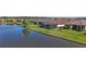 Scenic backyard view of homes alongside a peaceful lake, featuring lush greenery and screened in pool areas at 11414 Juglans Dr, Odessa, FL 33556