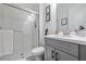 Cozy bathroom features a glass door shower, grey vanity, and decorative wall art at 11414 Juglans Dr, Odessa, FL 33556