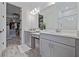 Bathroom with dual vanity sinks, stone countertops, and walk in closet at 11414 Juglans Dr, Odessa, FL 33556