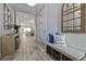 Inviting foyer featuring wood-look tile flooring, decorative mirror and bench with storage at 11414 Juglans Dr, Odessa, FL 33556