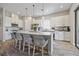 Spacious kitchen with white cabinets, stainless steel appliances, island with seating, and hardwood floors at 11414 Juglans Dr, Odessa, FL 33556