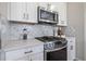 Close-up of the kitchen featuring stainless steel appliances and grey mosaic tile backsplash at 11414 Juglans Dr, Odessa, FL 33556