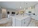 Open-concept living space featuring wood-look tile floors and a large kitchen island with pendant lighting at 11414 Juglans Dr, Odessa, FL 33556