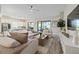 Open-concept living room with hardwood floors, plush seating, and a view of the kitchen at 11414 Juglans Dr, Odessa, FL 33556