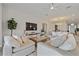 Bright living room with plush seating, hardwood floors, and a view of the dining room and entry at 11414 Juglans Dr, Odessa, FL 33556