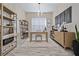 Home office with natural light, built-in shelving, modern chandelier, and hardwood floors at 11414 Juglans Dr, Odessa, FL 33556