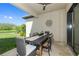 Covered outdoor dining area with ceiling fan and views of the lush backyard and nearby lake at 11414 Juglans Dr, Odessa, FL 33556