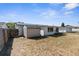 Backyard featuring a storage shed and the rear of the home with solar panels on the roof at 11422 Yellowwood Ln, Port Richey, FL 34668