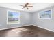 Bedroom features wood-look flooring, two windows and ceiling fan at 11422 Yellowwood Ln, Port Richey, FL 34668