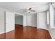 Inviting bedroom with hardwood floors, ceiling fan, and access to additional rooms at 11422 Yellowwood Ln, Port Richey, FL 34668