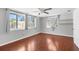 Comfortable bedroom featuring hardwood floors, ceiling fan, and multiple windows at 11422 Yellowwood Ln, Port Richey, FL 34668
