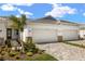 Charming home exterior featuring a tile roof, stone accents, paved driveway, and fresh landscaping at 12323 Hearts Ease St, Venice, FL 34293