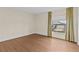 Simple bedroom with hardwood floors and a window with curtains at 131 Bluff View Dr # 101, Belleair Bluffs, FL 33770