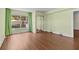 Bright bedroom with wood floors, green walls and curtains, plus natural light from a window overlooking the outdoors at 131 Bluff View Dr # 101, Belleair Bluffs, FL 33770