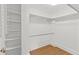 Walk-in closet featuring white shelving and racks, along with flooring that matches the style used in the bedroom at 131 Bluff View Dr # 101, Belleair Bluffs, FL 33770