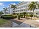 Low-rise condominium exterior with palm trees and manicured landscaping at 131 Bluff View Dr # 101, Belleair Bluffs, FL 33770