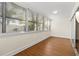 A sunroom featuring large windows with blinds, laminate floors, and bright natural light at 131 Bluff View Dr # 101, Belleair Bluffs, FL 33770