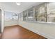 Bright sunroom featuring a wall of large windows with blinds and laminate floors, offering serene views at 131 Bluff View Dr # 101, Belleair Bluffs, FL 33770