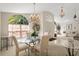 Formal dining room featuring a glass table, decorative chandelier, and arched window with natural light at 15014 Arbor Hollow Dr, Odessa, FL 33556