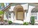 Inviting front entrance featuring an arched doorway, double doors, and decorative window with decorative columns at 15014 Arbor Hollow Dr, Odessa, FL 33556