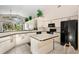 Well-lit kitchen with a central island, modern appliances, and ample cabinet space for storage at 15014 Arbor Hollow Dr, Odessa, FL 33556