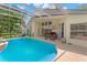 Relaxing pool area with an attached covered lanai and outdoor dining set at 15014 Arbor Hollow Dr, Odessa, FL 33556