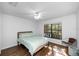 Cozy bedroom with hardwood flooring, ceiling fan, and a bright window overlooking scenic outdoor views at 17557 Fairmeadow Dr, Tampa, FL 33647