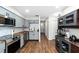 Fully equipped kitchen boasts stainless steel appliances, gray cabinets, and hardwood floors at 17557 Fairmeadow Dr, Tampa, FL 33647