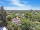 Aerial view showing a house surrounded by tall trees, mature landscaping, and glimpses of the distant bay at 1775 Michigan Ne Ave, St Petersburg, FL 33703