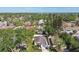 Aerial view of a charming home surrounded by lush landscaping, tall trees, and glimpses of the nearby lake at 1775 Michigan Ne Ave, St Petersburg, FL 33703