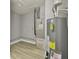 Finished basement featuring a utility area with water heater, air conditioner, and wood tile flooring at 1775 Michigan Ne Ave, St Petersburg, FL 33703