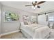 Cozy bedroom with light wood floors, a queen-sized bed, a ceiling fan, and windows providing ample natural light at 1775 Michigan Ne Ave, St Petersburg, FL 33703
