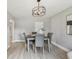 Dining room featuring stylish light fixture, gray walls, wood-look tile flooring, and seating for four guests at 1775 Michigan Ne Ave, St Petersburg, FL 33703