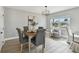 Dining room featuring stylish light fixture, gray walls, wood-look tile flooring, and seating for five guests at 1775 Michigan Ne Ave, St Petersburg, FL 33703