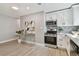 Kitchen area featuring stainless steel appliances, white cabinetry, stylish backsplash, and hardwood floors at 1775 Michigan Ne Ave, St Petersburg, FL 33703