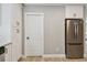 Kitchen area with stainless steel refrigerator, white cabinets, and adjacent doorway at 1775 Michigan Ne Ave, St Petersburg, FL 33703