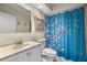 Bathroom with white vanity and blue floral shower curtain at 1849 Diane Dr, Clearwater, FL 33759