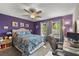 Bright bedroom featuring calming purple walls, a ceiling fan, and lots of natural light at 1849 Diane Dr, Clearwater, FL 33759