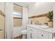 Bright bathroom featuring tub/shower combo, white vanity, and neutral tiled walls at 2214 Wilshire Dr, Dunedin, FL 34698