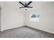A simple bedroom with neutral paint, trim, carpet, and a single window at 2214 Wilshire Dr, Dunedin, FL 34698