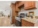 A modern kitchen featuring stainless steel appliances, granite countertops, and wood cabinetry at 2214 Wilshire Dr, Dunedin, FL 34698