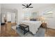 This main bedroom offers a ceiling fan, two windows and a comfortable bench at the foot of the bed at 2214 Wilshire Dr, Dunedin, FL 34698