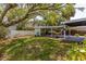 Expansive backyard featuring a covered patio, lush lawn, and mature trees at 2304 S Occident St, Tampa, FL 33629