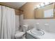 Classic bathroom featuring a white tub and shower, toilet and sink with a large mirror at 2808 W Lake Ave, Tampa, FL 33607