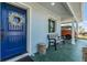 Inviting front porch with a blue door, decorative wreath, and comfortable bench seating at 2808 W Lake Ave, Tampa, FL 33607