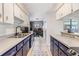 Long view of kitchen featuring open shelving, tile floors, blue and white cabinetry and stainless steel appliances at 2808 W Lake Ave, Tampa, FL 33607
