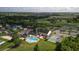 Aerial view of community clubhouse with pool, shuffleboard courts, and beautifully landscaped grounds at 29408 Princeville Dr, San Antonio, FL 33576