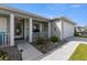 Inviting front porch with seating, decorative plants, and a well-lit walkway leading to the front door at 29408 Princeville Dr, San Antonio, FL 33576